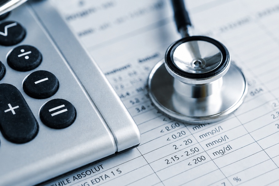 Calculator, stethoscope, and medical health care bills